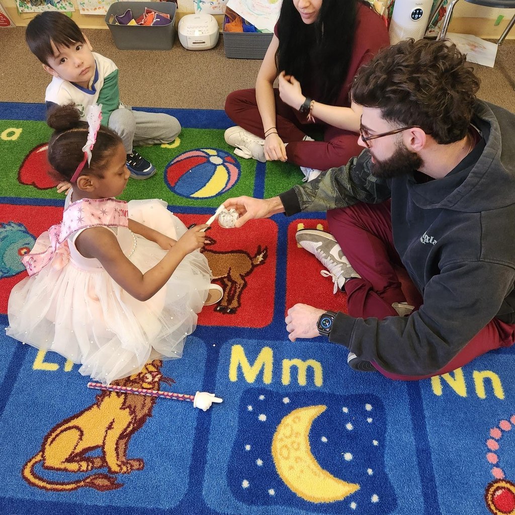 A dental student from LECOM showing a student how to brush teeth. 