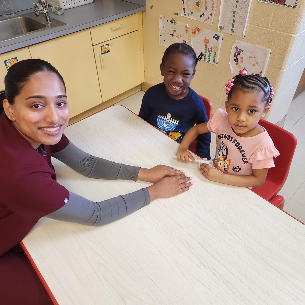 A women sitting with two kids.