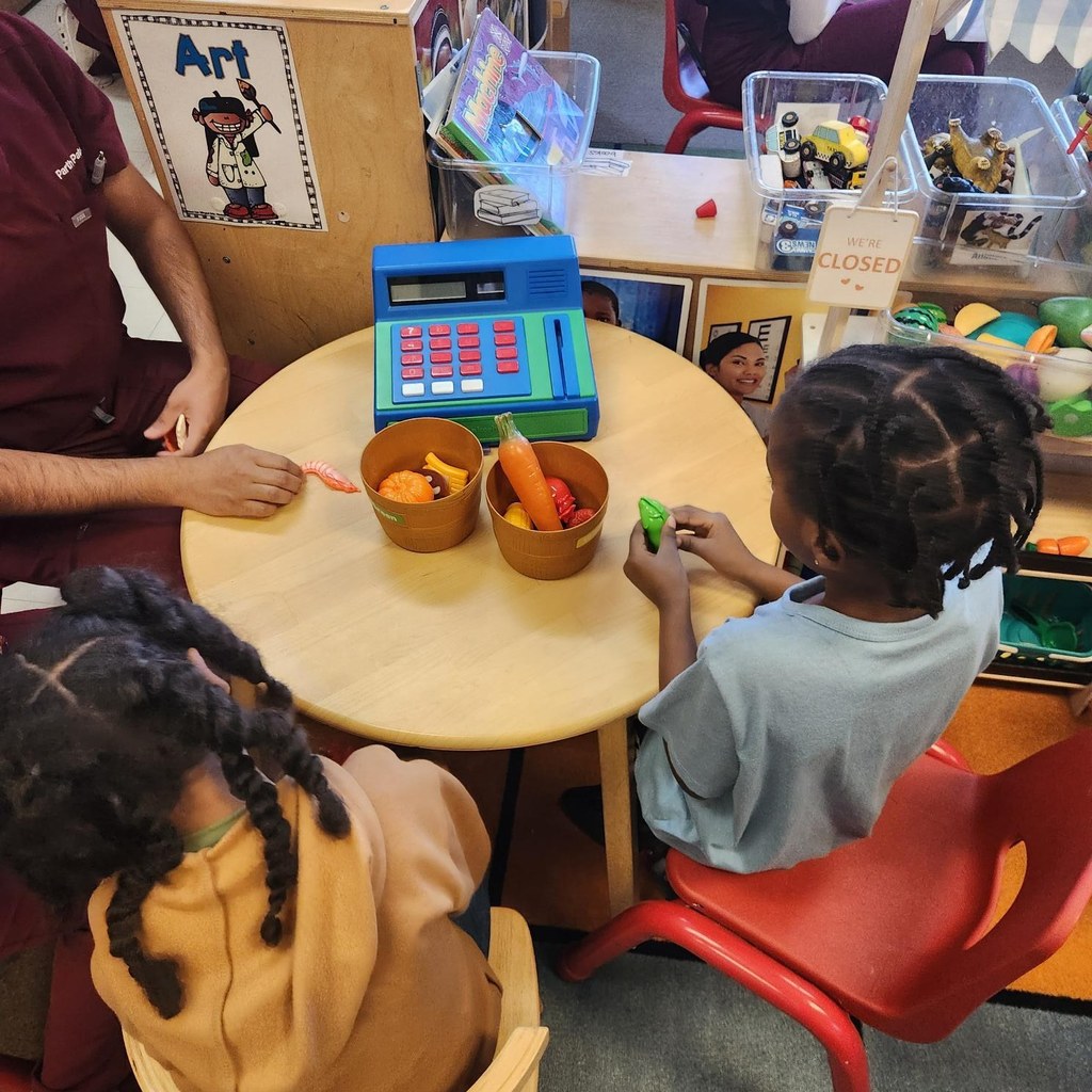 Kids and adult playing with toy food. 