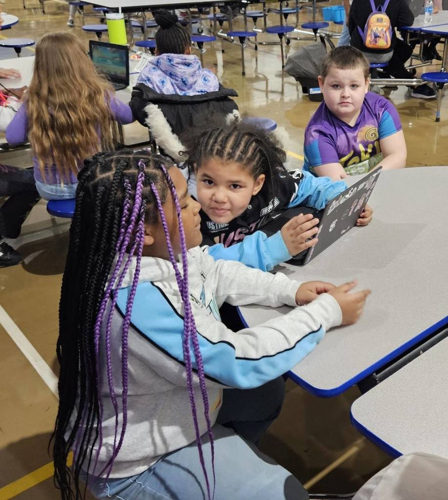 Students sitting at circle tables in school. 