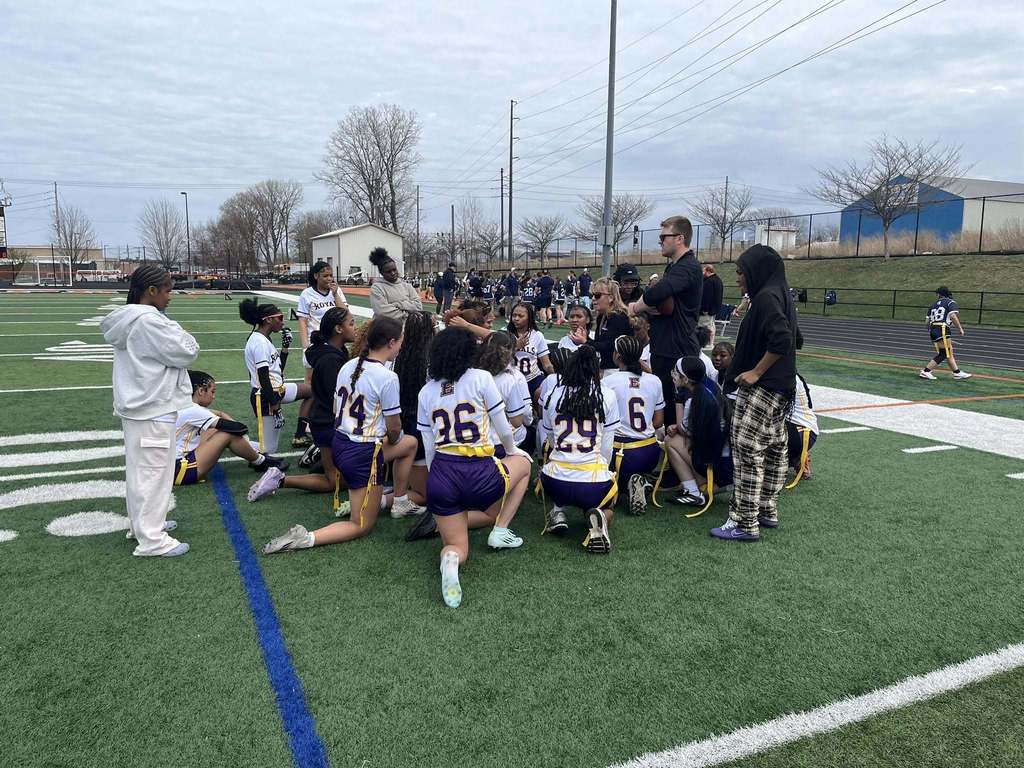 Erie High Royals Girl Flag Football Team Huddle before a game on the field. 