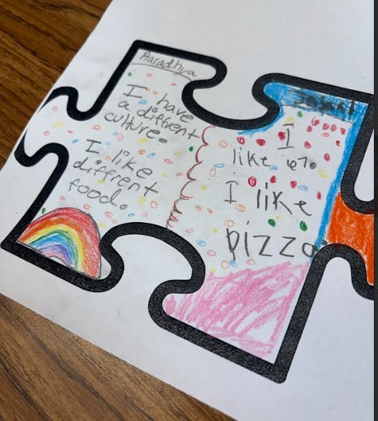 Hand-drawn puzzle pieces on a white paper, featuring phrases like "I have a different culture" and "I like pizza," with a rainbow.