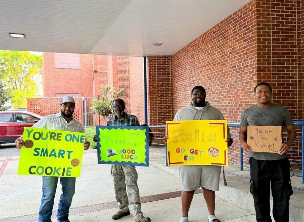 Male figures in our students' lives holding up signs to wish the 3rd graders good luck on their test.
