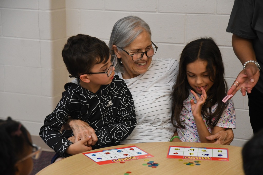 adult holding kids and smiling during bingo night