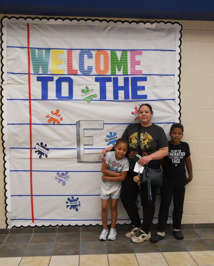 family standing in from of 'Welcome to the E sign