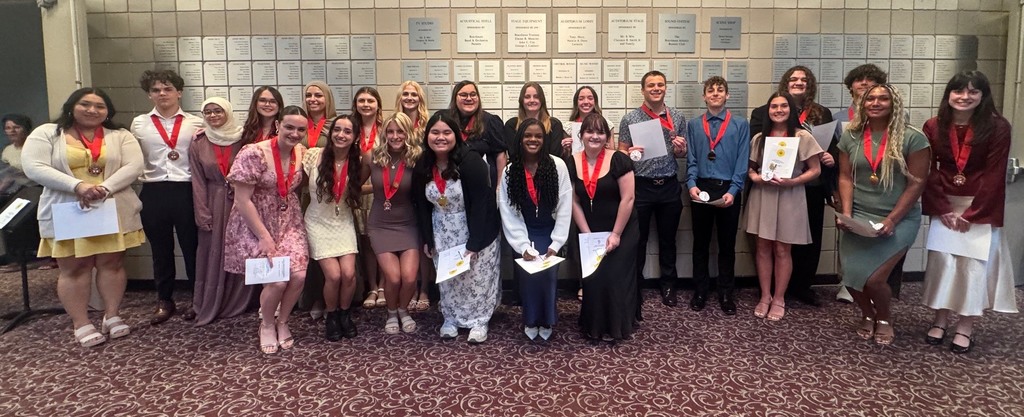 16 students in the performing arts center with certificates for new induction into spanish nhs