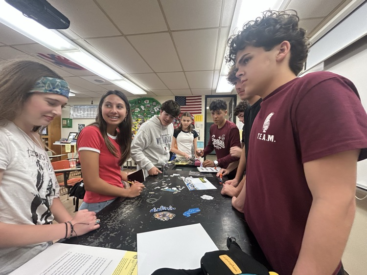 students assembling an eco system with paper cut outs 