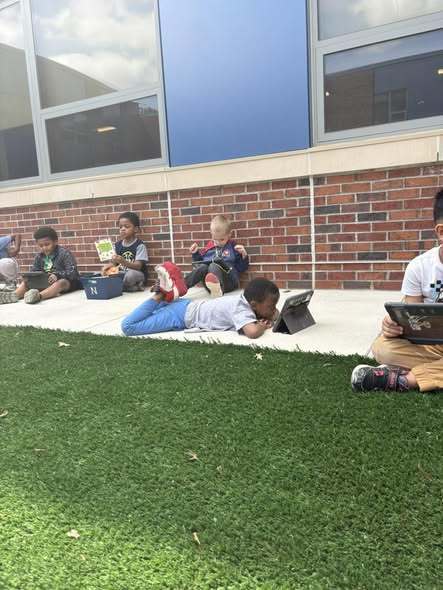 Students using their ipads and learning outside.