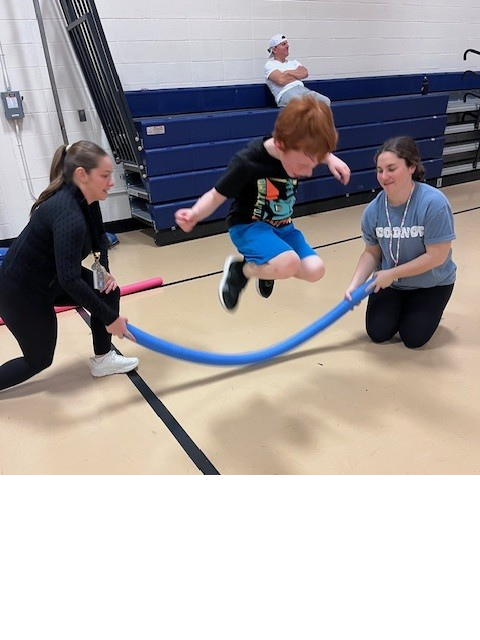 student playing jump rope with two people turning the rope