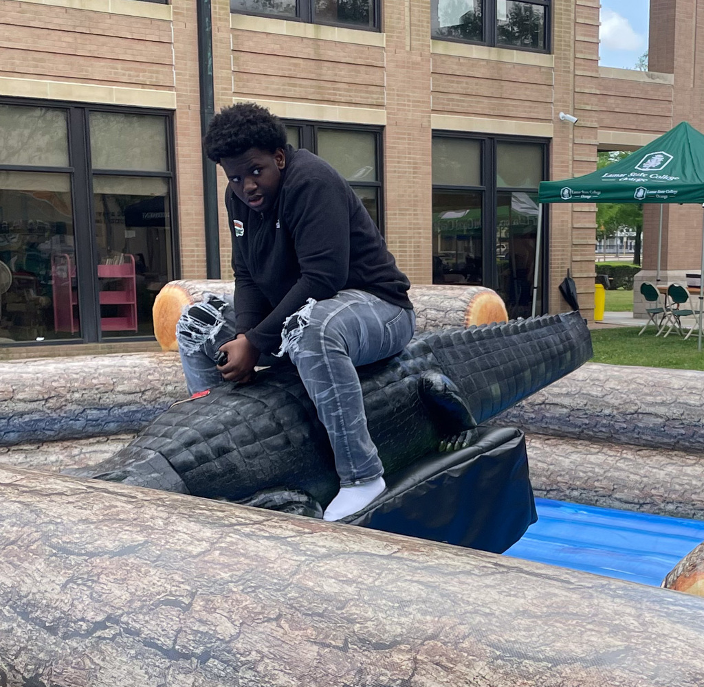 student riding a mechanical gator