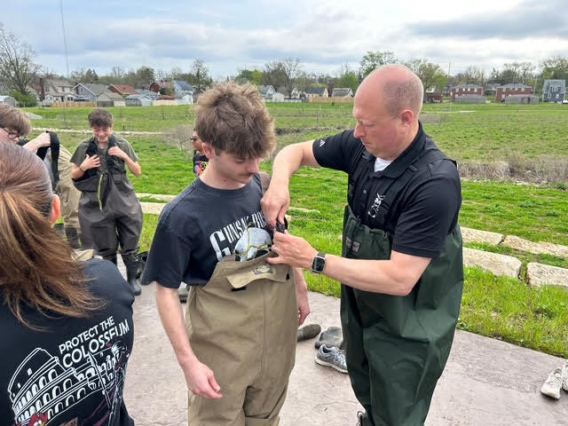 Principal Zura helping a student with his waders