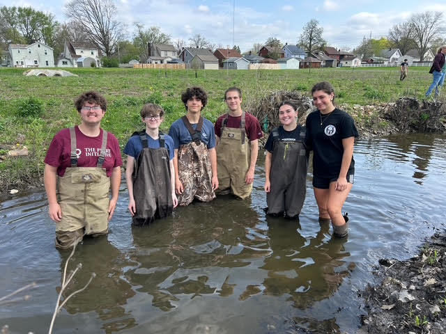 6 students in waders in the stream