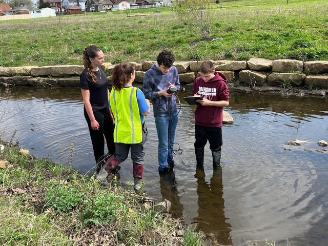 Students working on water purity indicators with Kent State field agent