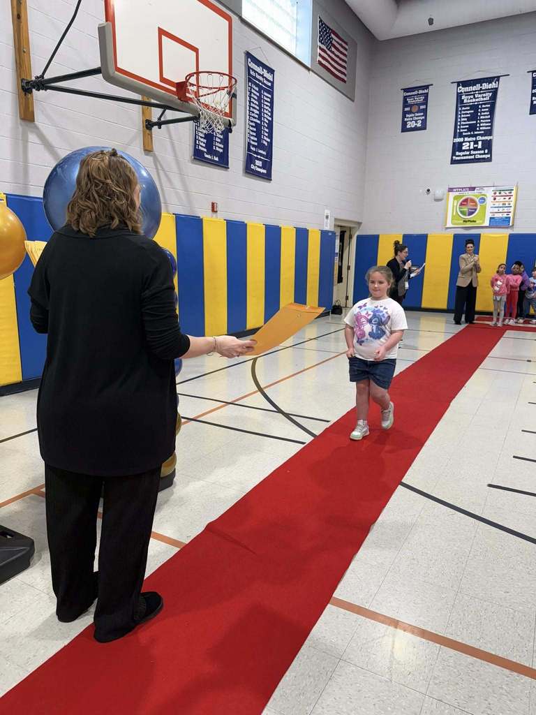 A student accepting their awards during the Awards assembly. 