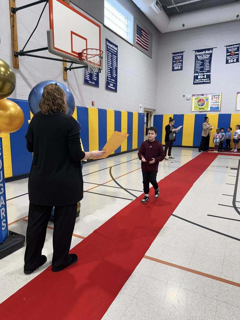 A student accepting their awards during the Awards assembly. 