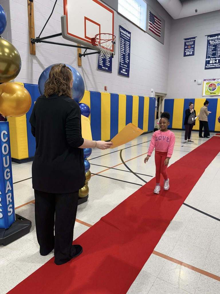 A student accepting their awards during the Awards assembly. 