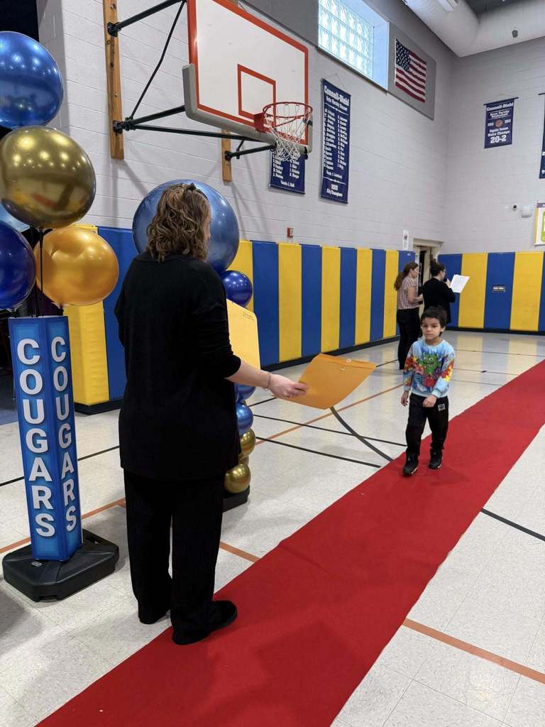 A student accepting their awards during the Awards assembly. 