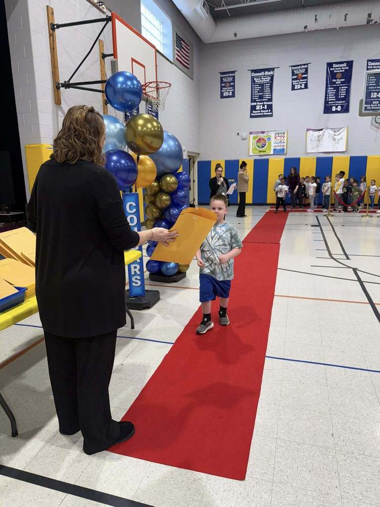 A student accepting their awards during the Awards assembly. 