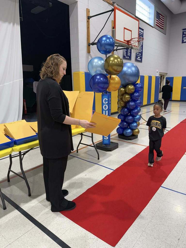 A student accepting their awards during the Awards assembly. 