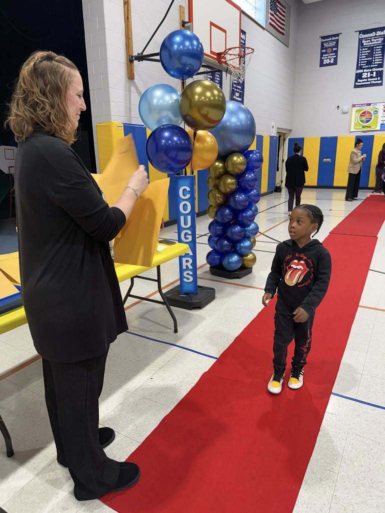 A student accepting their awards during the Awards assembly. 