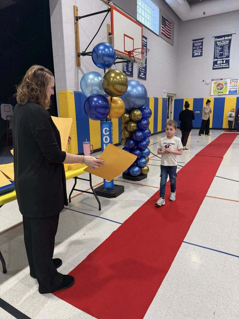 A student accepting their awards during the Awards assembly. 