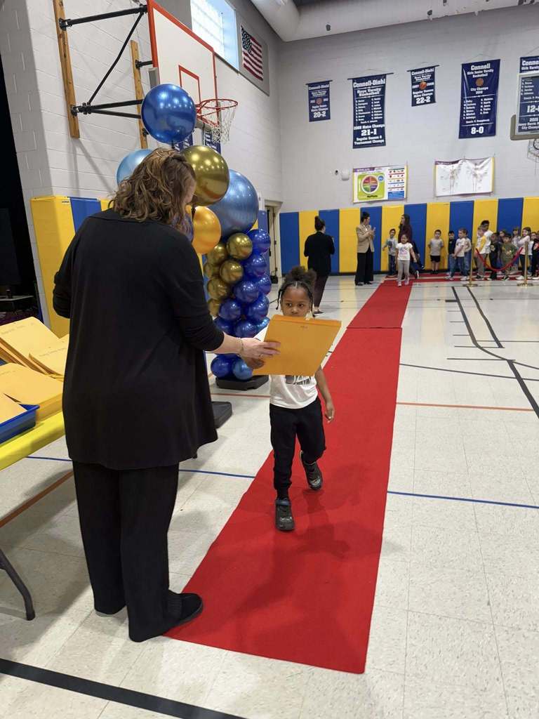 A student accepting their awards during the Awards assembly. 