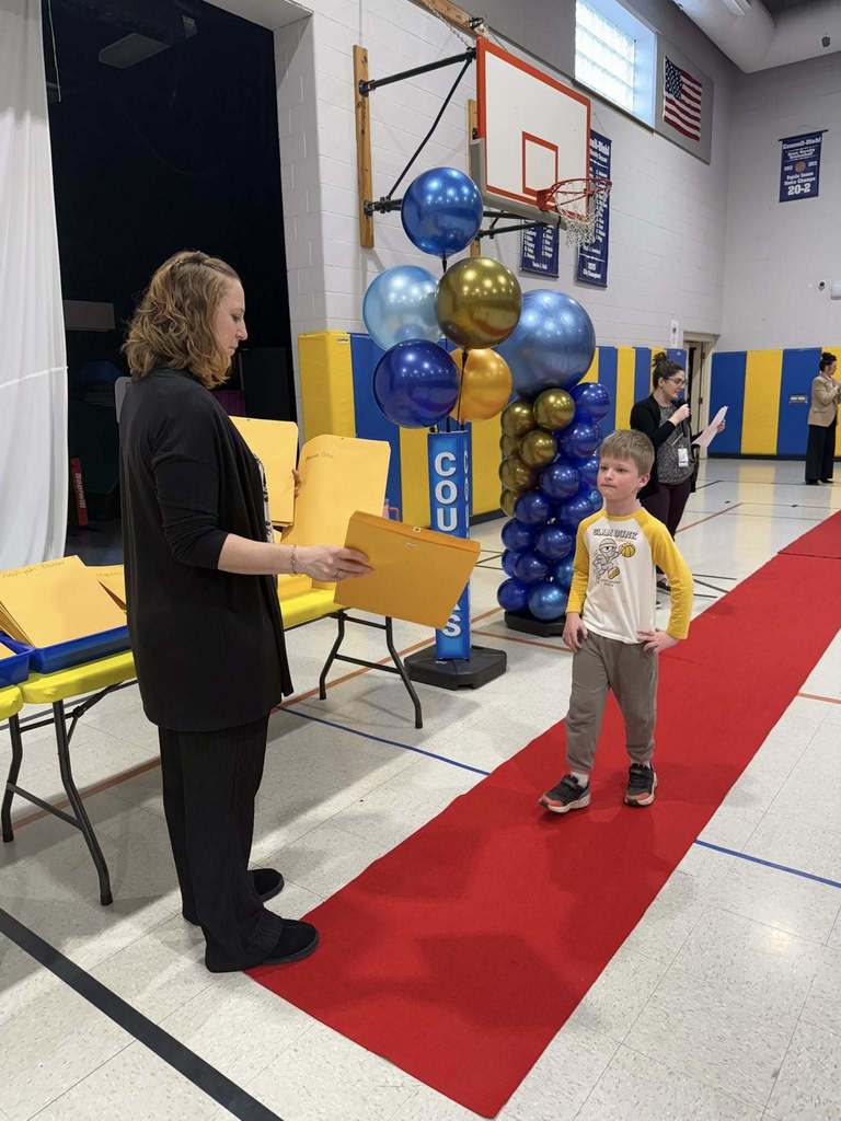 A student accepting their awards during the Awards assembly. 