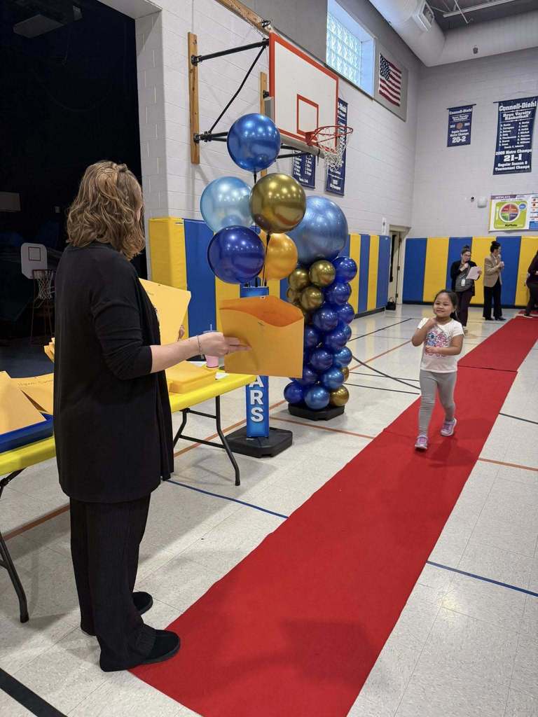 A student accepting their awards during the Awards assembly. 