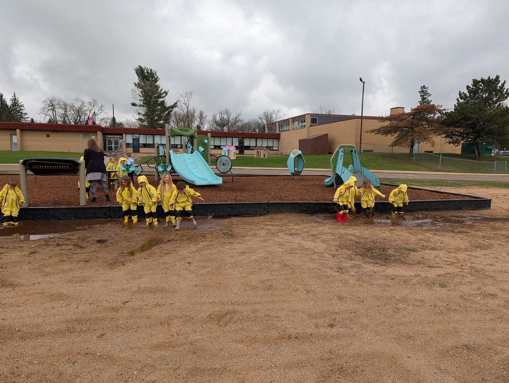 Preschool students playing mud puddles