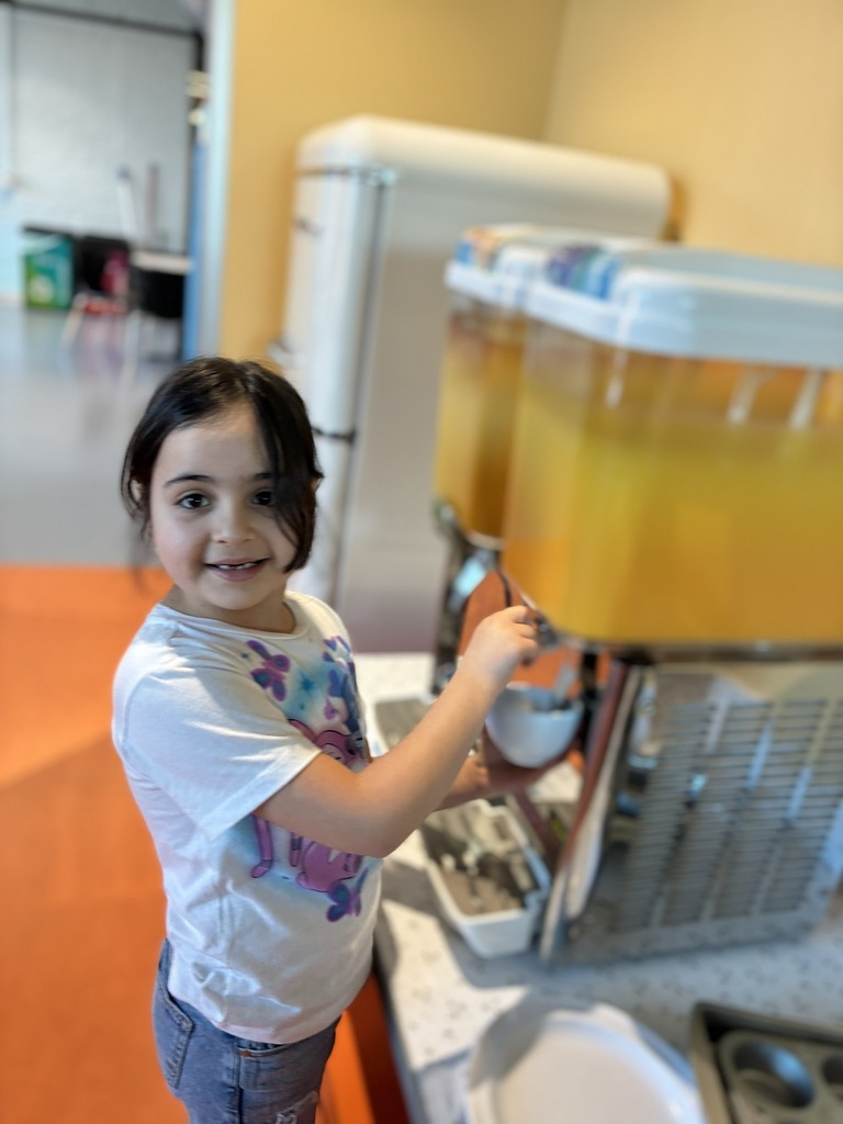 A student getting juice from a juice dispenser. 