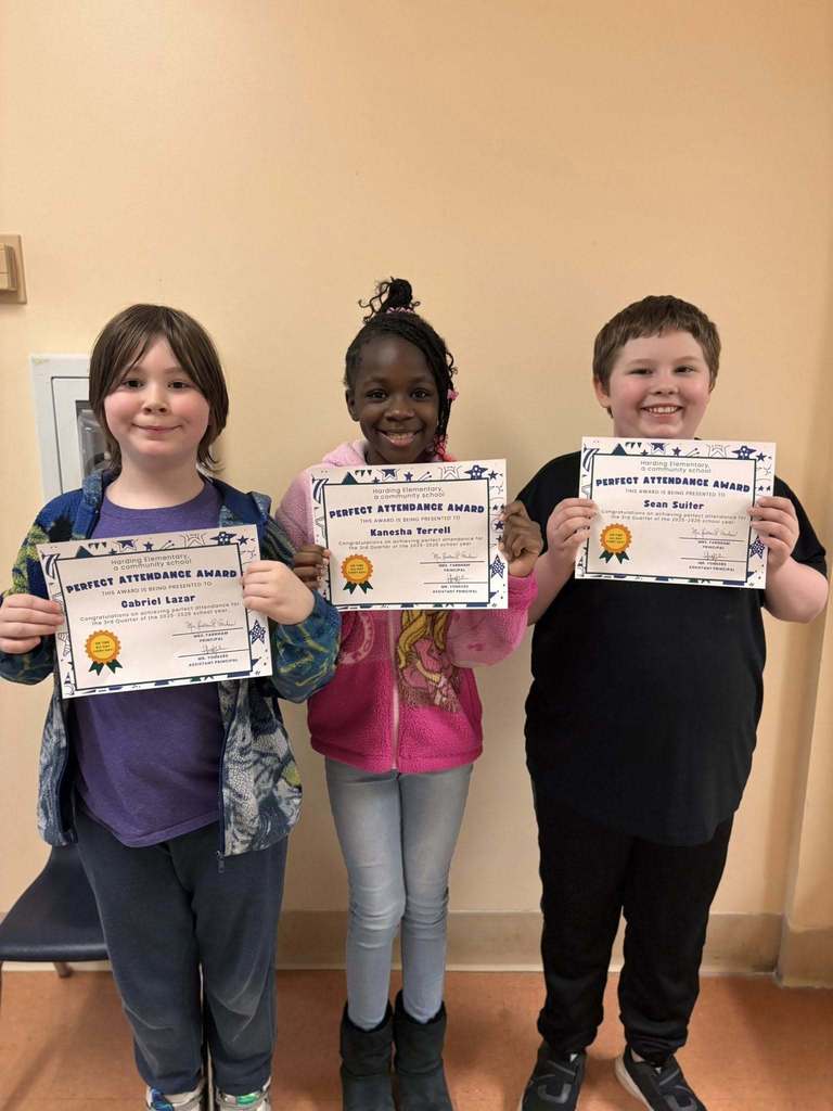 Students posing while they hold their perfect attendance awards. 