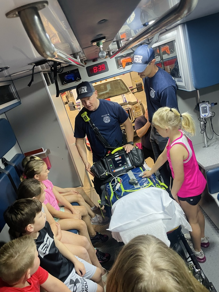 first graders on a field trip being shown around in an ambulance 