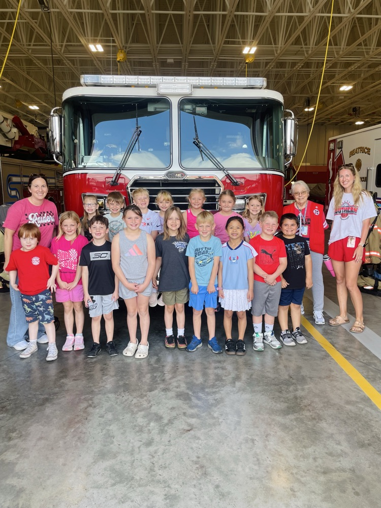 first graders teacher and foster grandparent in front of fire truck 