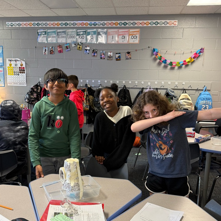 three students showing their water filtration system
