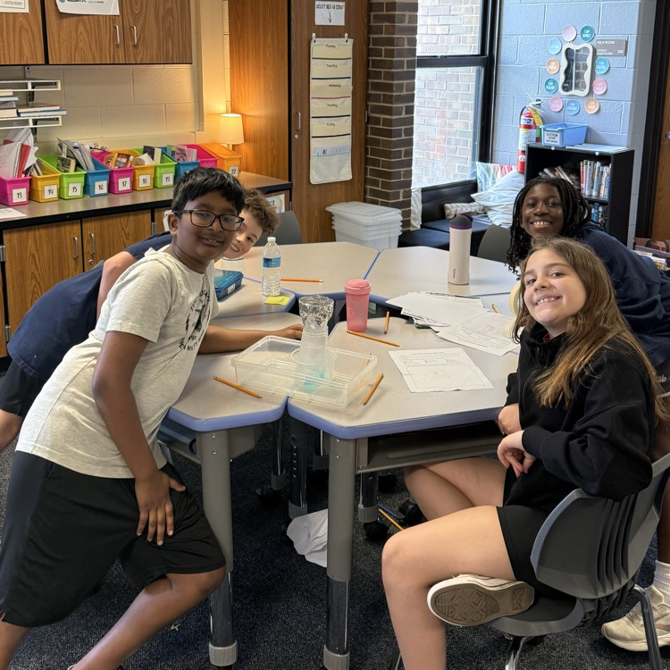 four students showing their water filtration system