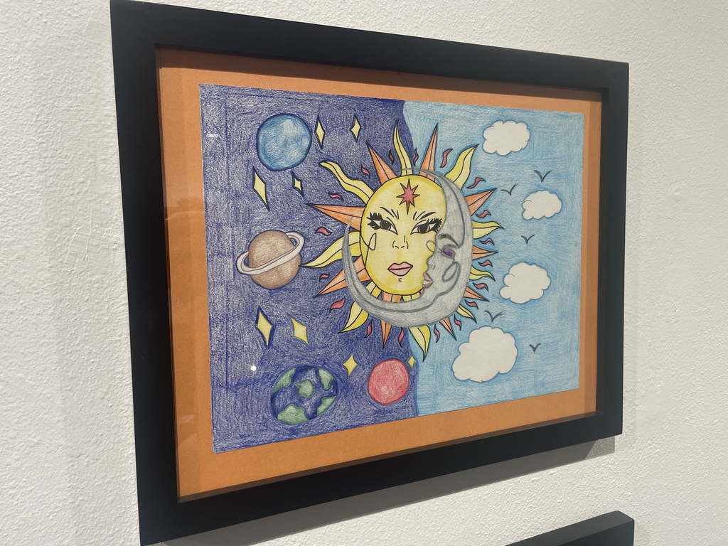 student colored pencil drawing of an entwined sun and moon with planets