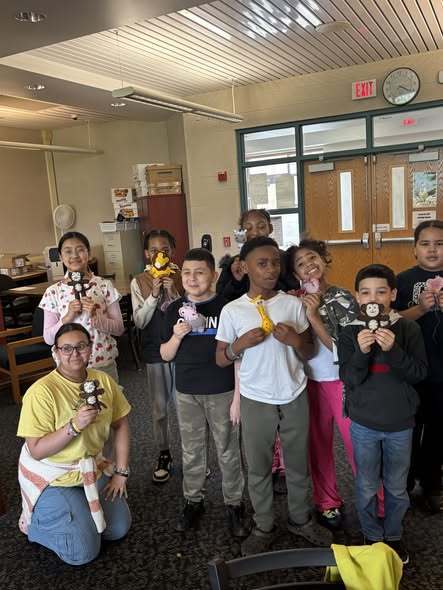 Students posing with their hand sown animals. 