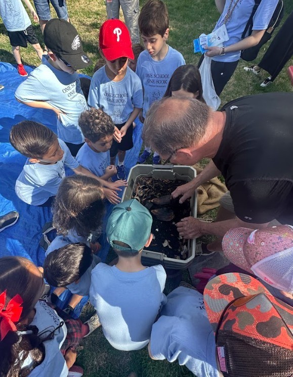 GES students peer into a crate containing living creatures at the Arbor Day celebration in Newtown Boro.