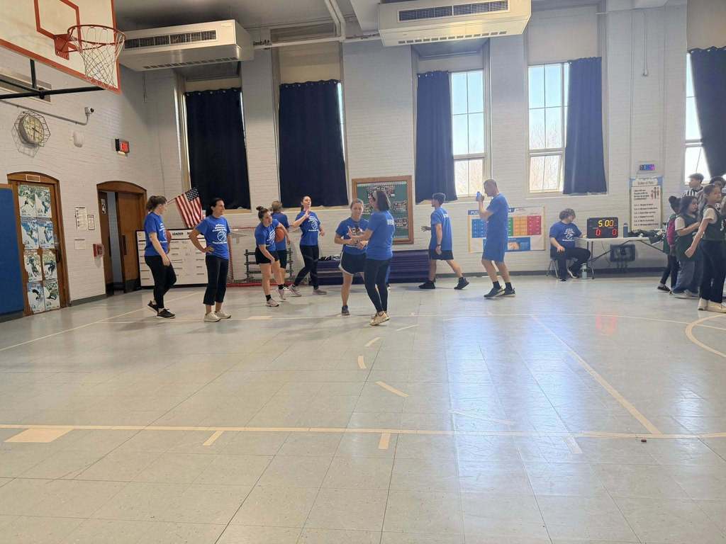 Staff standing in the school gym. 