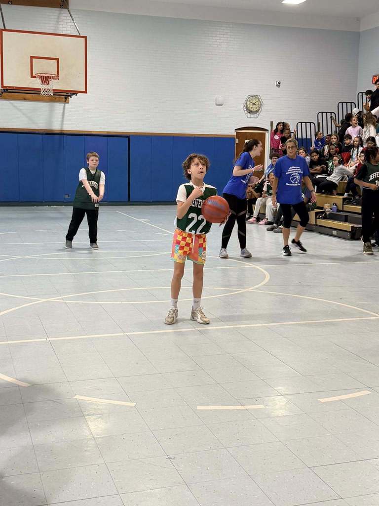 A student holding a basketball and is about to throw it. 