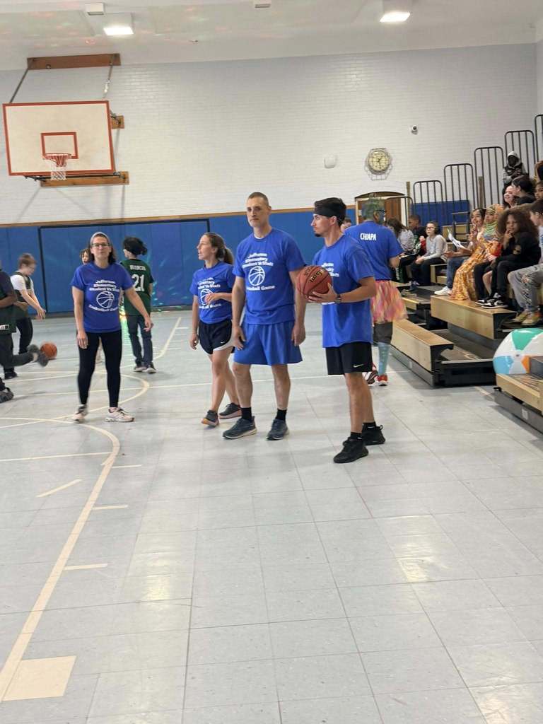 Staff standing in the school gym. 