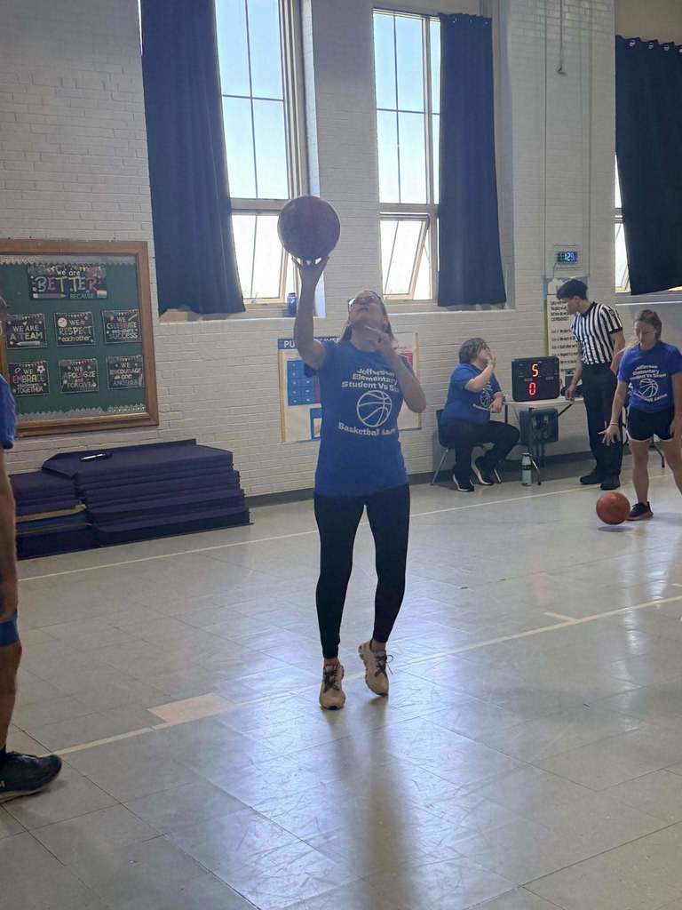 A staff member throwing a basketball. 