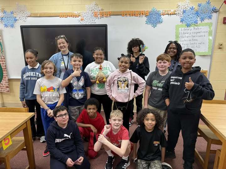 Students and teacher posing in a classroom.