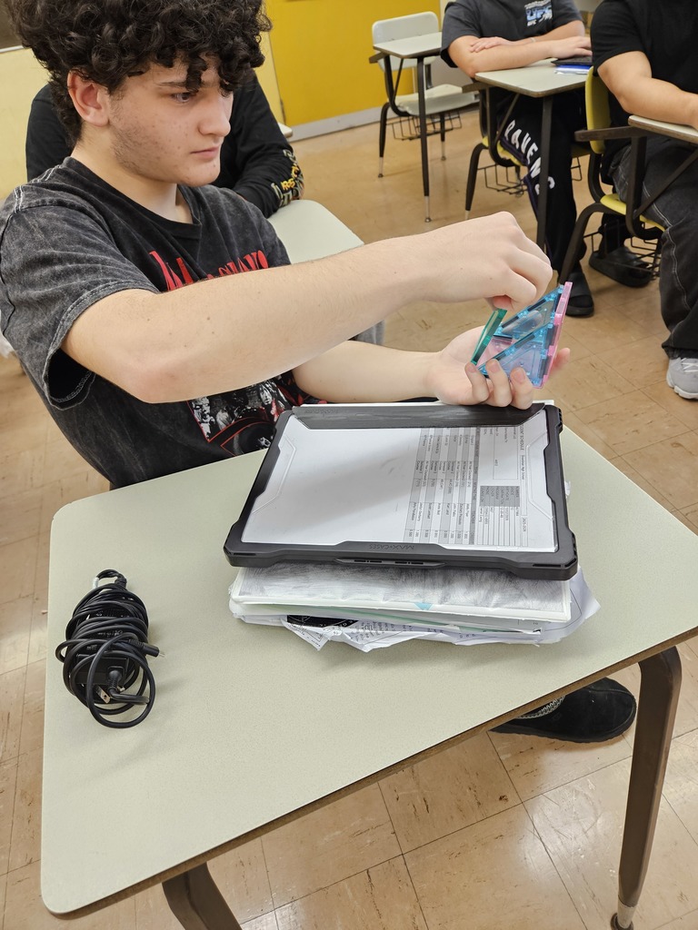 student holds picasso tiles in a half section of a cube