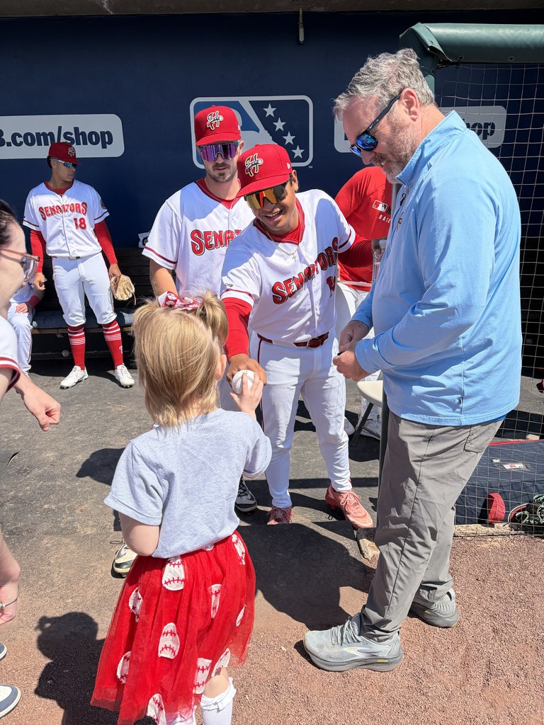 Student holding a baseball while meeting with Harrisburg Senators baseball players.