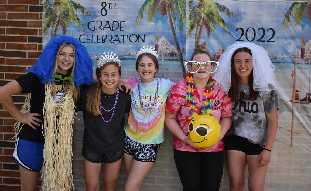 Five 8th graders pose in the photo booth.