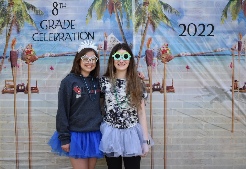 Two girls in sunglasses and tutus pose in the photo booth.