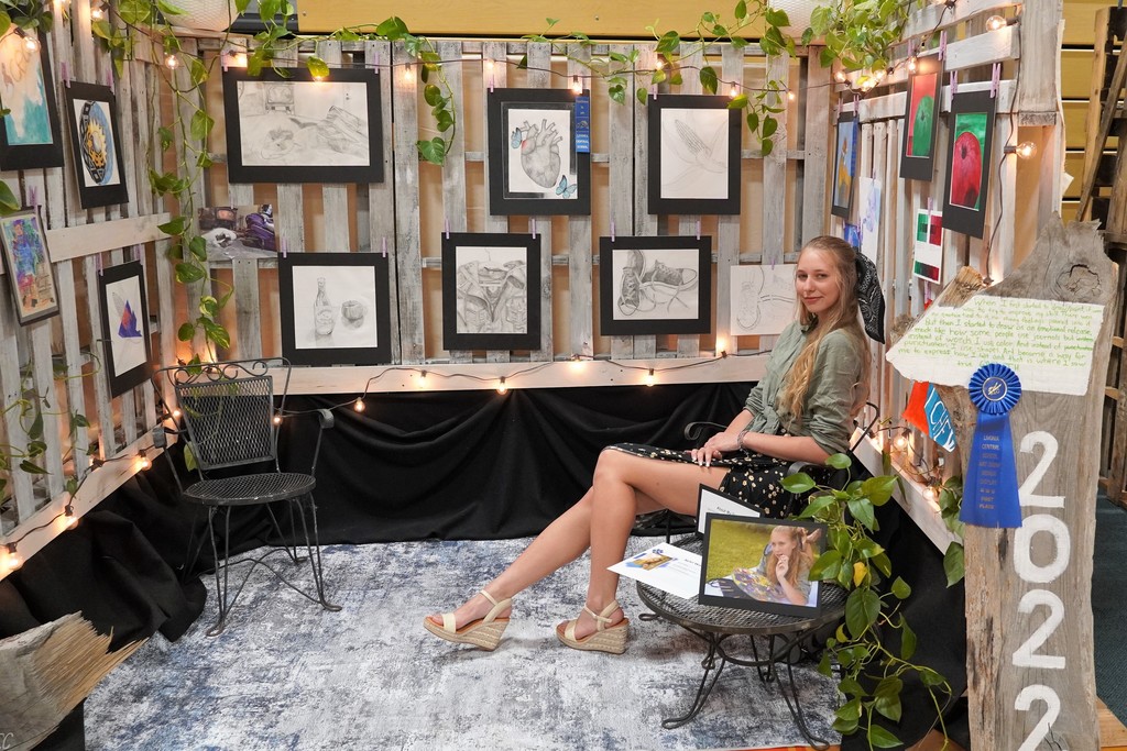 student sitting in winning art display