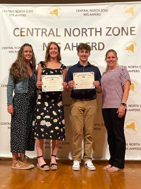 four people posing with awards