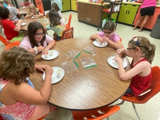 Four students around a table making goop.  